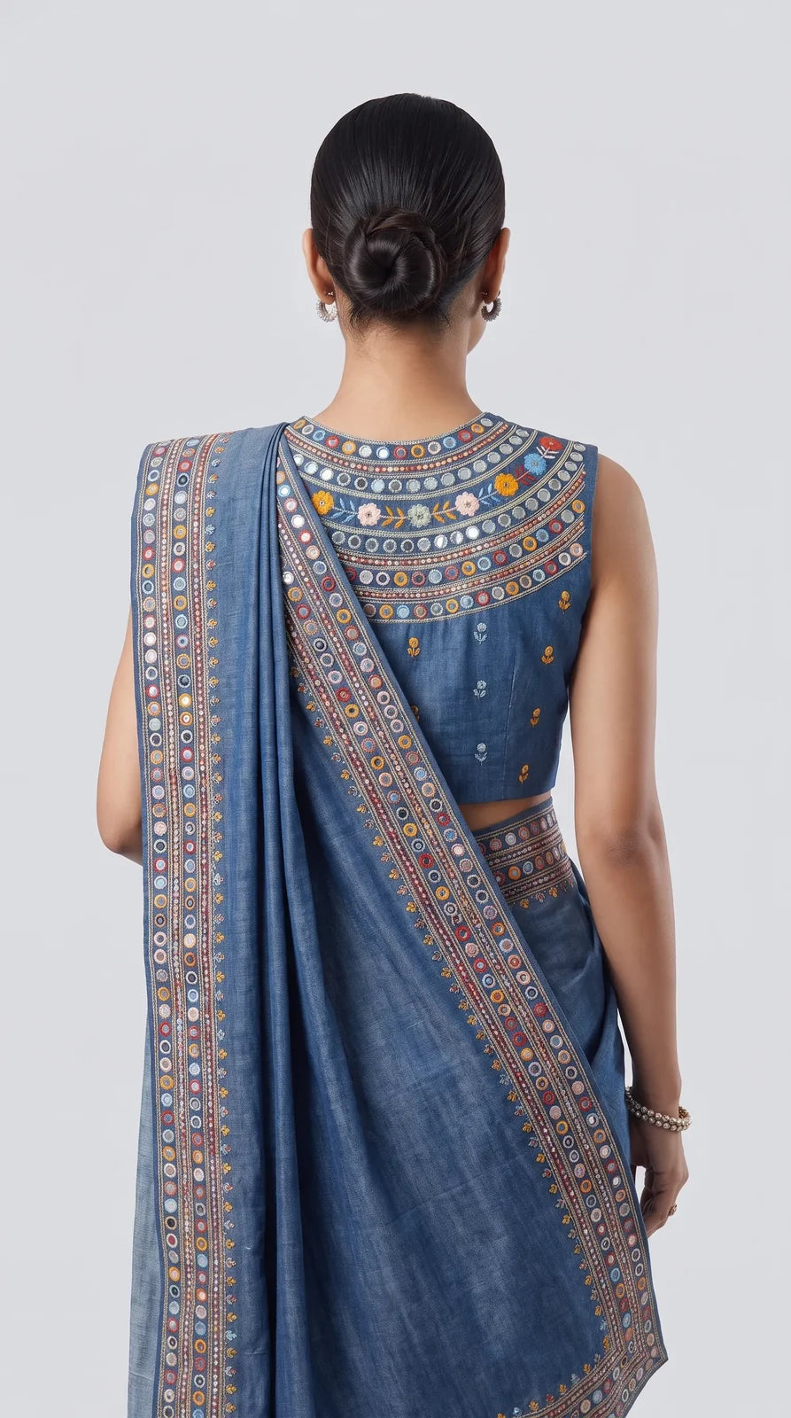 Back view of blue denim saree set showing embroidered blouse and mirror work border